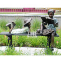 Modern outdoor bronze boy and girl reading on bench sculpture